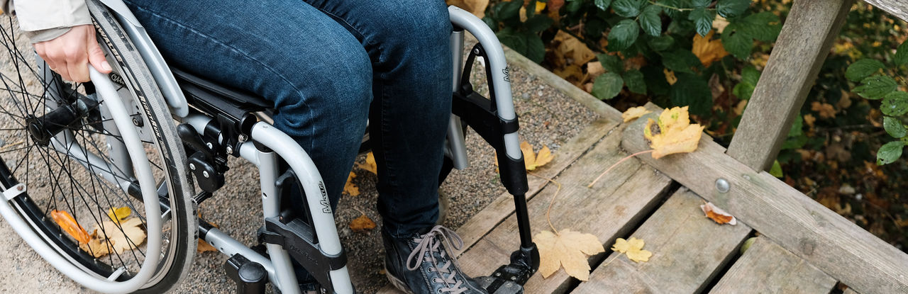 On this picture, you can see the legs of a person sitting in a wheelchair trying to get over an edge onto the bridge.