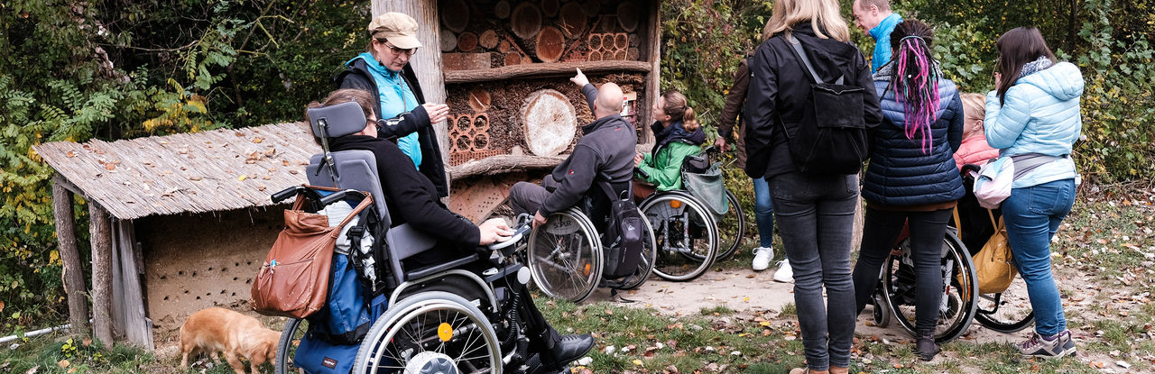 This picture shows members of the project team trying out what it feels like to experience nature in a wheelchair. Many of the people are in wheelchairs, all others are assistants and responsible for safety on the road.